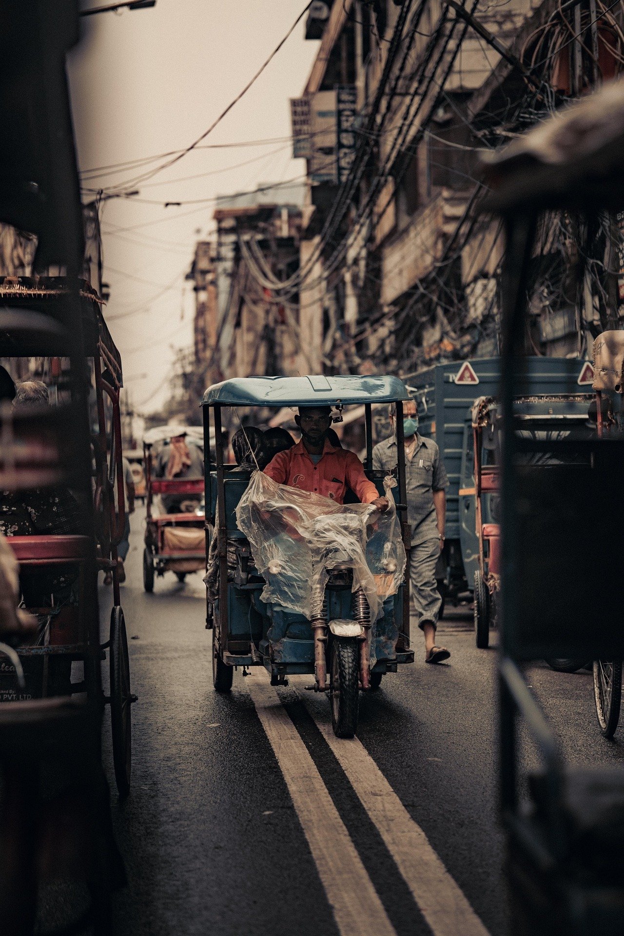 A narrow street in Old Delhi with an e-rickshaw